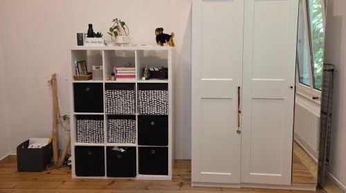 Ein Kleiderschrank mit großem Spiegel und einem Regal