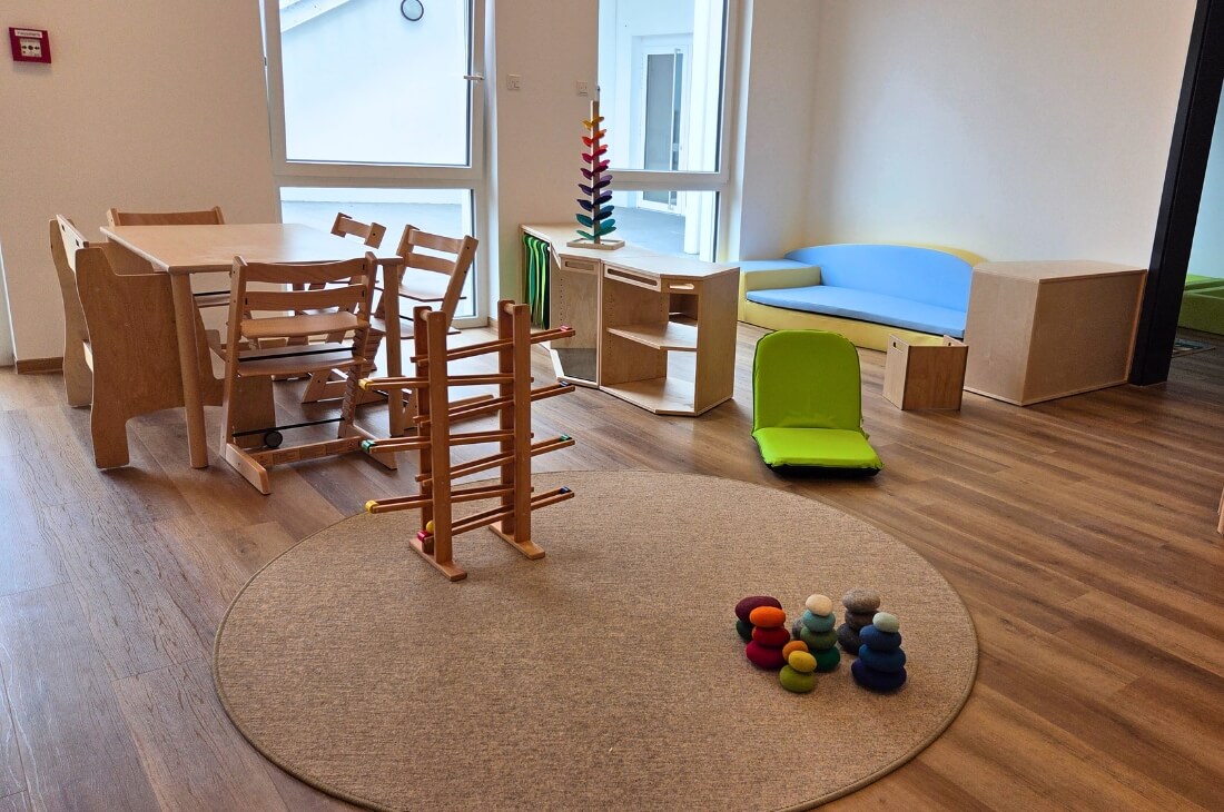 Ein Raum mit einem Tisch und Stühlen für Kinder und ein Sofa auf Bodenhöhe