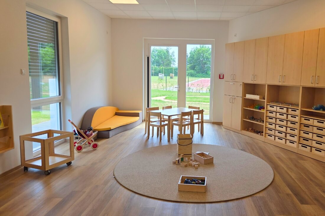 Ein Ram mit Spielsachen, einem Tisch, Sofa und Stühlen für Kinder