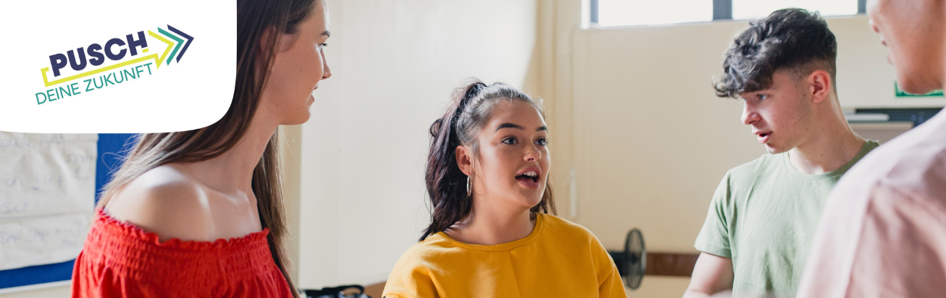 Auf dem Bild sieht man drei Jugendliche - zwei junge Frauen und einen Mann in einer Gesprächssituation. Es scheint, als gehöre der Raum, in dem sie stehen zu einer Schule. 